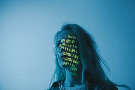 Woman with binary code projected onto her face.